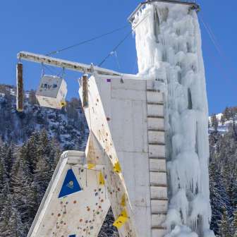 Gefrorener Eisturm in Malbun mit sichtbaren Kletterrouten und Sicherungspunkten, vor blauem Himmel
