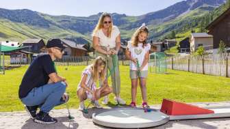 Familie spielt Minigolf auf der Alpen-Minigolf-Anlage in Malbun