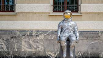 Silver astronaut sculpture "Space Conductor" by Max Grüter in front of the government building in Vaduz – modern art in public space.