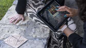 Player uses iPad to solve puzzles in Outdoor Adventure Room