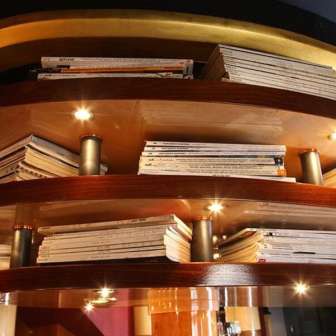 Wooden shelf with illuminated books as ceiling panelling
