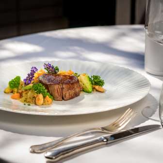 Main course with juicy meat, fresh vegetables and decorative flowers