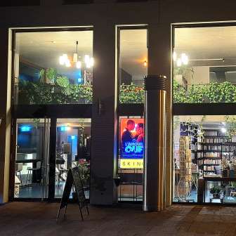 Beleuchtete Außenansicht des Skino-Kinos in Schaan bei Nacht, mit großen Glasfronten und einladender Atmosphäre.