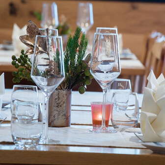 Close-up of a beautifully set table with glasses, cutlery and small plant decoration
