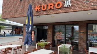 Exterior view of the Kuro restaurant with outdoor tables