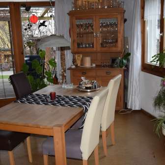 Friendly dining area in the studio in Eschen with wooden table, aquarium and lots of natural light.