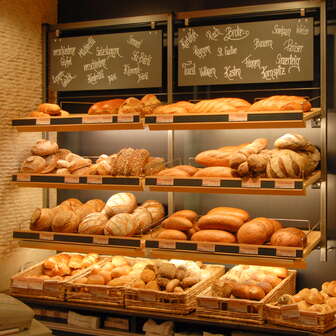 Gefülltes Regal mit Broten und anderen Köstlichkeiten in der Bäckerei Konditorei Amann
