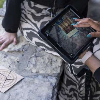 Spielerin verwendet iPad zur Rätsellösung beim Outdoor Adventure Room
