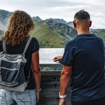 Couple looking at the mountain table on the terrace of the Sareis mountain inn