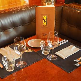 Table set with menu in the leather seating area of the Vanini Café