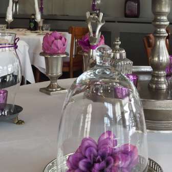 Table decoration with purple flowers on white tablecloth