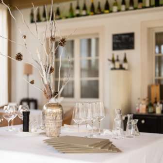 Decorative bar in the Vivid restaurant with stylish glasses, bottles and natural lighting