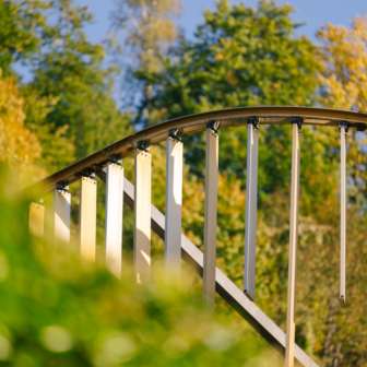 Close-up of the arched metal arch with vertical slats of the Centre for Art in front of an autumnal forest backdrop in Vaduz.