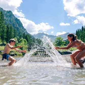 Children splashing around in the Gänglesee in Steg