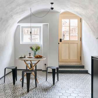 Entrance of the apartment with round dining table and kitchenette